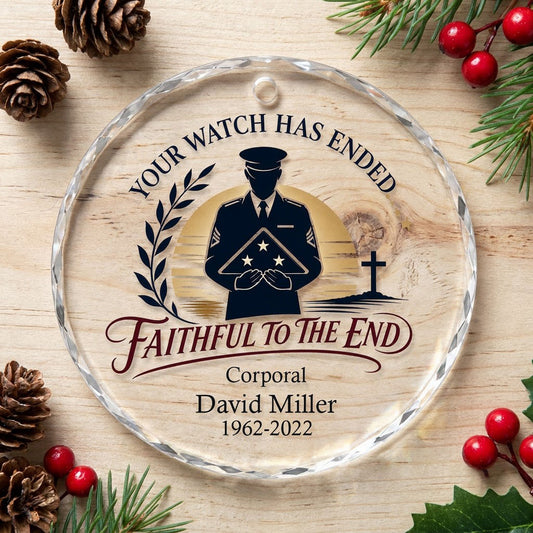 Round glass ornament with officer silhouette holding a folded flag, golden sunset, cross, and the words YOUR WATCH HAS E