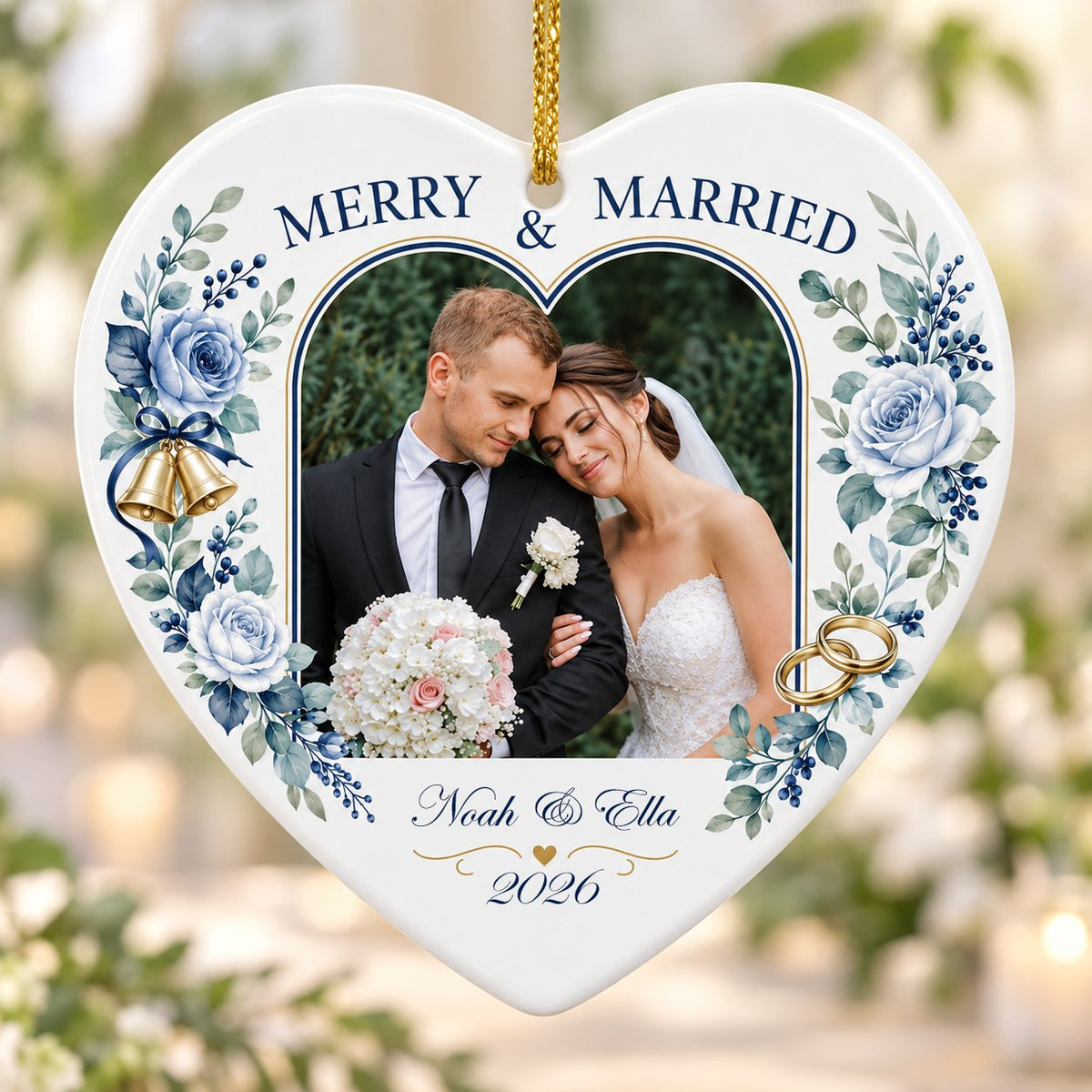 Heart ceramic ornament with “MERRY & MARRIED,” dusty blue florals, wedding bells, rings, and a heart-shaped photo frame.