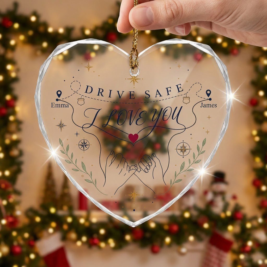 Heart glass ornament showing pinky promise hands, map pins, compass roses, green sprigs, and DRIVE SAFE and I LOVE YOU.