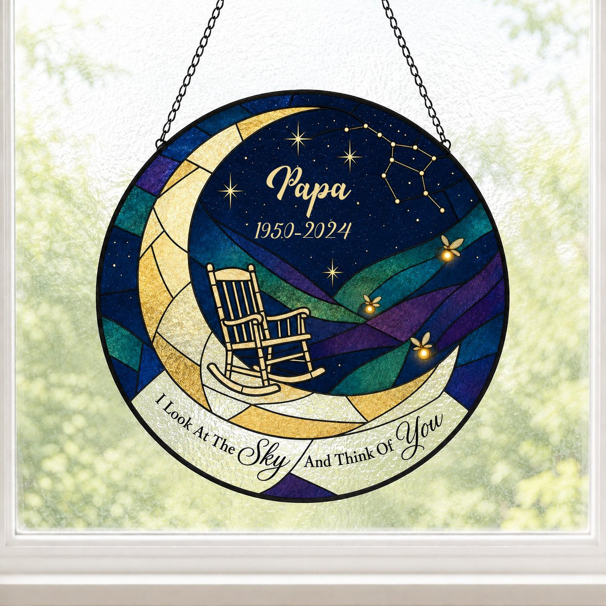 Round stained-glass suncatcher with a crescent moon, rocking chair, fireflies and a memorial banner.