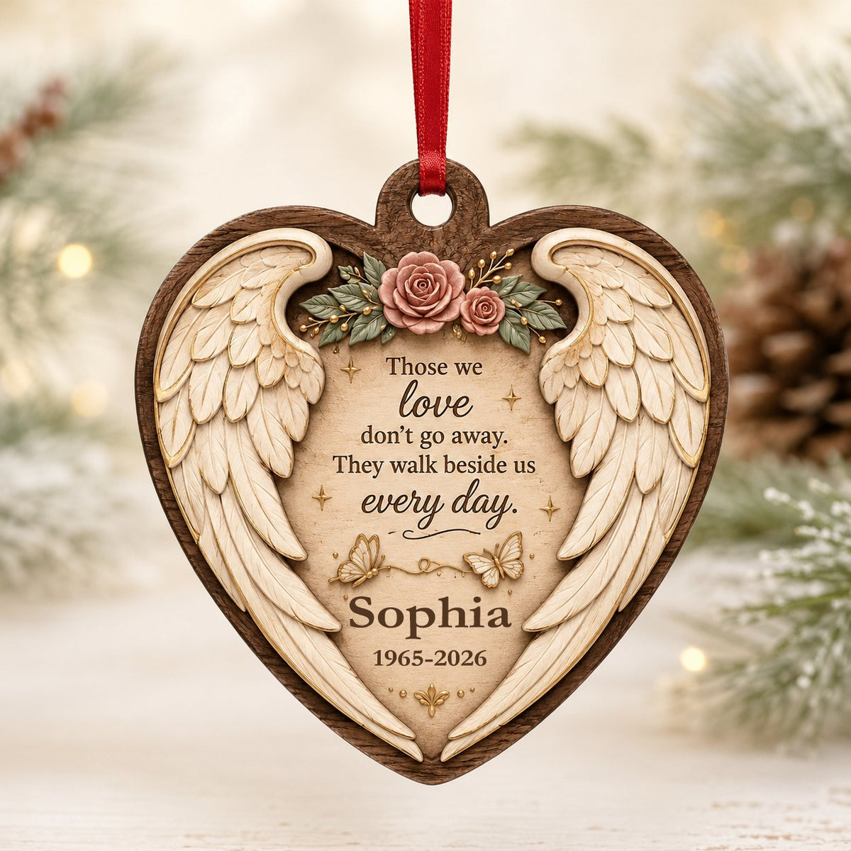 Heart-shaped wood ornament with angel wings, pink roses, butterflies, and a memorial quote with name and dates.