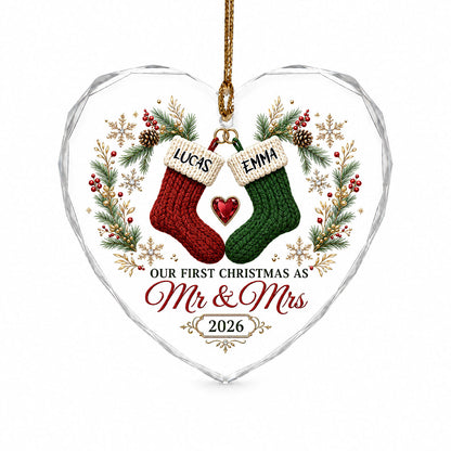Heart-shaped glass ornament with red and green stockings hanging from gold rings and a red gemstone heart