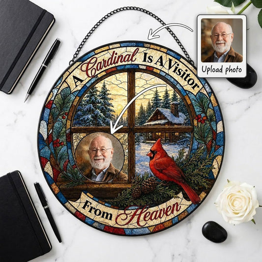 Stained glass suncatcher with a wooden four-pane window, snowy cabin scene, red cardinal on pine branches, and a circula