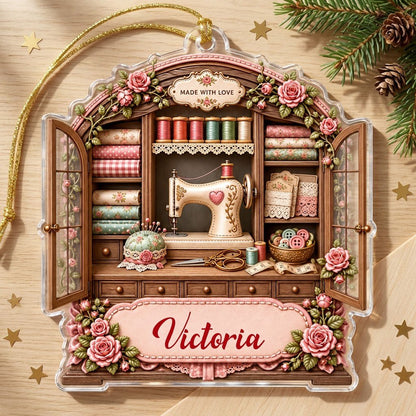 Acrylic ornament shaped like a sewing cabinet with roses, sewing machine, scissors and a pink name banner.