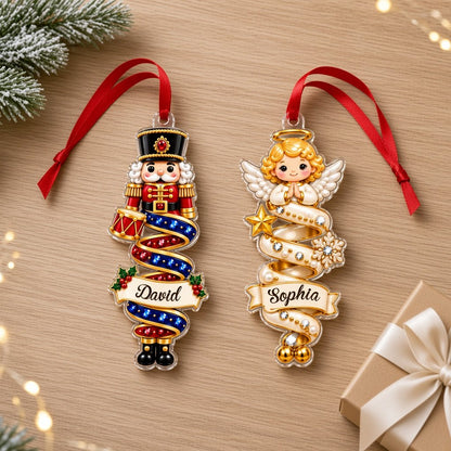 Custom-cut acrylic ornaments with a cartoon nutcracker and a praying angel wrapped in decorative ribbons.