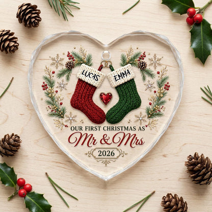 Heart-shaped glass ornament with red and green stockings hanging from gold rings and a red gemstone heart