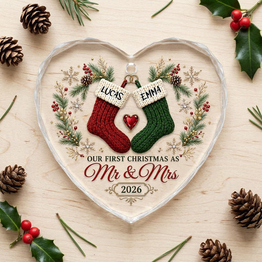 Heart-shaped glass ornament with red and green stockings hanging from gold rings and a red gemstone heart
