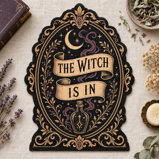 Gothic plaque sign reading "THE WITCH IS IN" with crescent moon, stars, purple smoke, potion bottle and ornate filigree 
