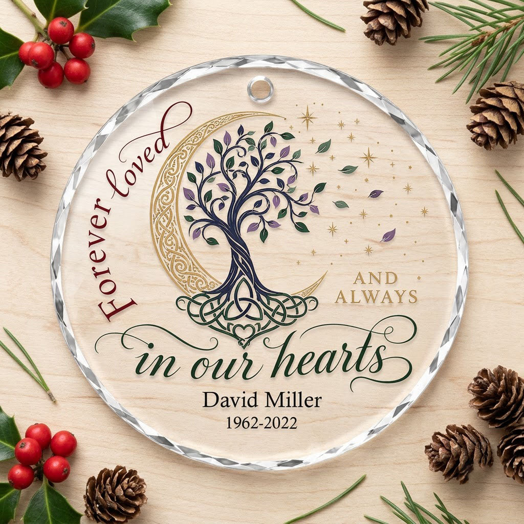 Round glass ornament with Celtic tree of life, gold crescent moon, stars, and phrase Forever loved in our hearts.