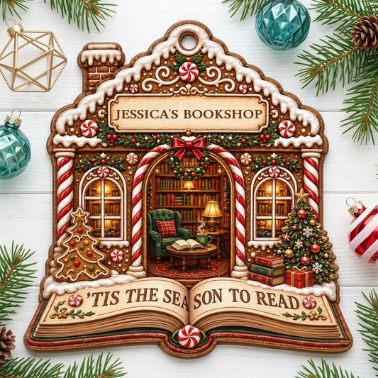 Gingerbread bookshop house ornament with candy canes, wreath, bookshelves, armchair, and an open book base