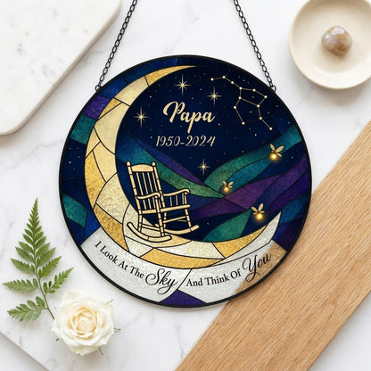 Round stained-glass suncatcher with a crescent moon, rocking chair, fireflies and a memorial banner.
