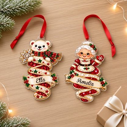 A custom-cut clear acrylic ornament shows a polar bear and Mrs. Claus in a jeweled spiral with a name banner and red rib