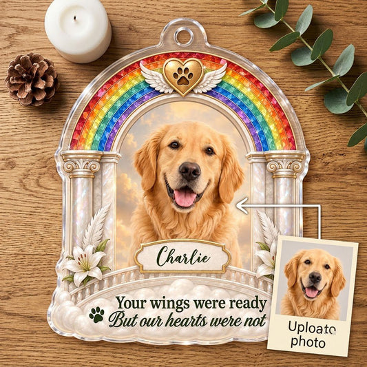 A rainbow arch pet memorial acrylic ornament with a winged golden heart, paw print, lilies, pillars, clouds and a photo 