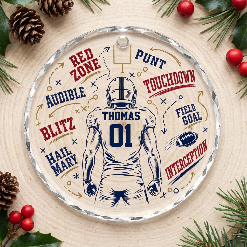 Round faceted glass ornament with football player back view, goalpost, football, and play diagrams in navy, dark red, an