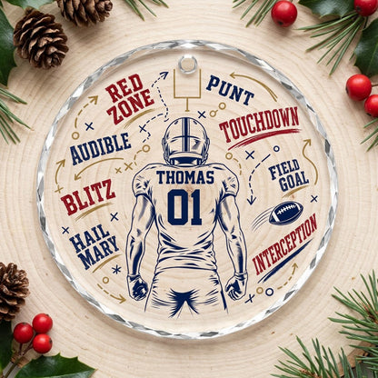 Round faceted glass ornament with football player back view, goalpost, football, and play diagrams in navy, dark red, an