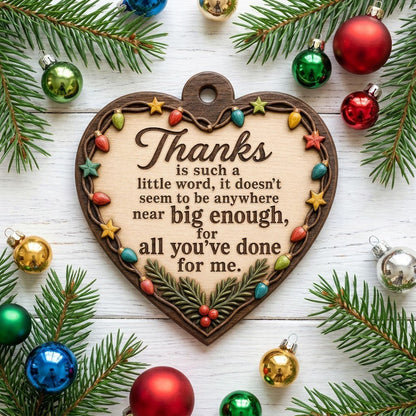 Heart-shaped wood ornament with a lights-and-stars border, pine sprigs with red berries, and a gratitude quote.