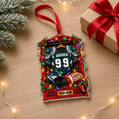 Acrylic ornament of a red football locker with a green jersey, helmet, football, lights and holly for Christmas