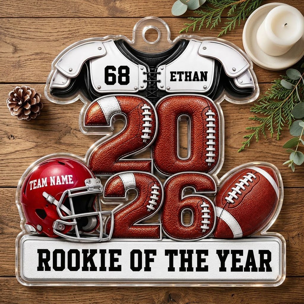 Acrylic ornament shaped like football gear with 2026 numbers, red helmet, ball and 'Rookie of the Year' nameplate.