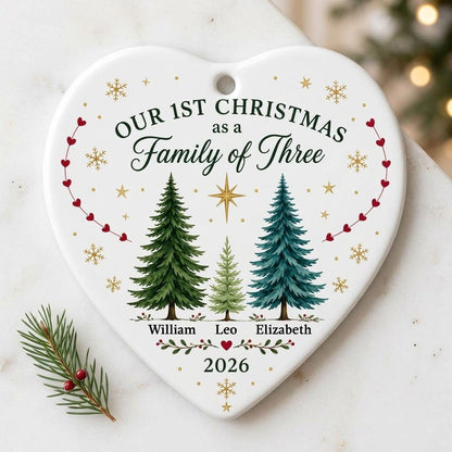 Heart ceramic ornament with three watercolor pine trees, a gold star, red heart garlands, and names with year.