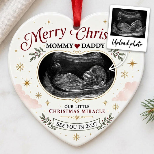 Heart ceramic ornament with ultrasound photo, gold starbursts, green leaves with red berries, and a bottom banner.