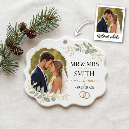 White scalloped ceramic medallion with MR & MRS, eucalyptus, gold rings, and a couple’s photo on the left.