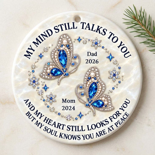 Round ceramic ornament with jeweled blue butterflies, floral rhinestones, and a cream marble background with memorial qu
