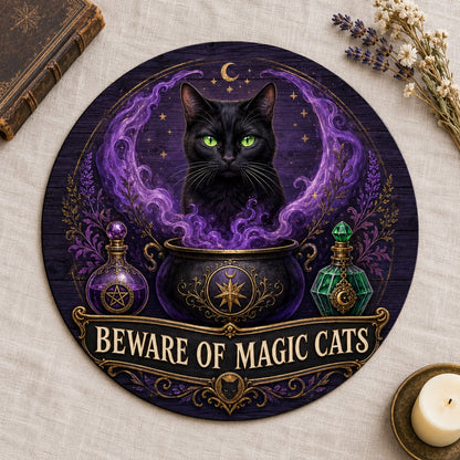 Round wooden sign with a black cat in purple smoke rising from a cauldron and the text BEWARE OF MAGIC CATS.