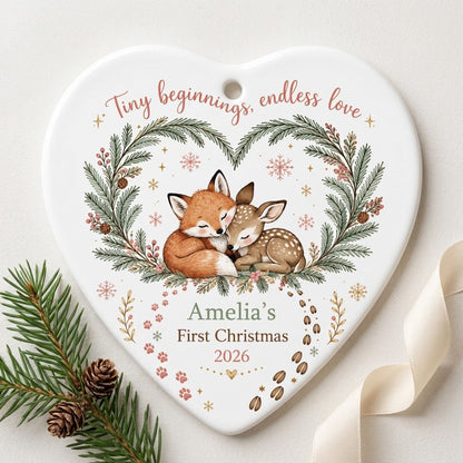 Heart ceramic ornament with sleeping baby fox and fawn in an evergreen wreath with berries and snowflakes.