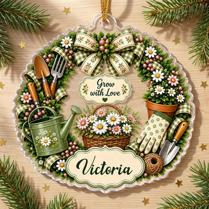 Scalloped acrylic ornament with a floral gardening wreath, tools, and "Grow with Love" plus a personalized name.
