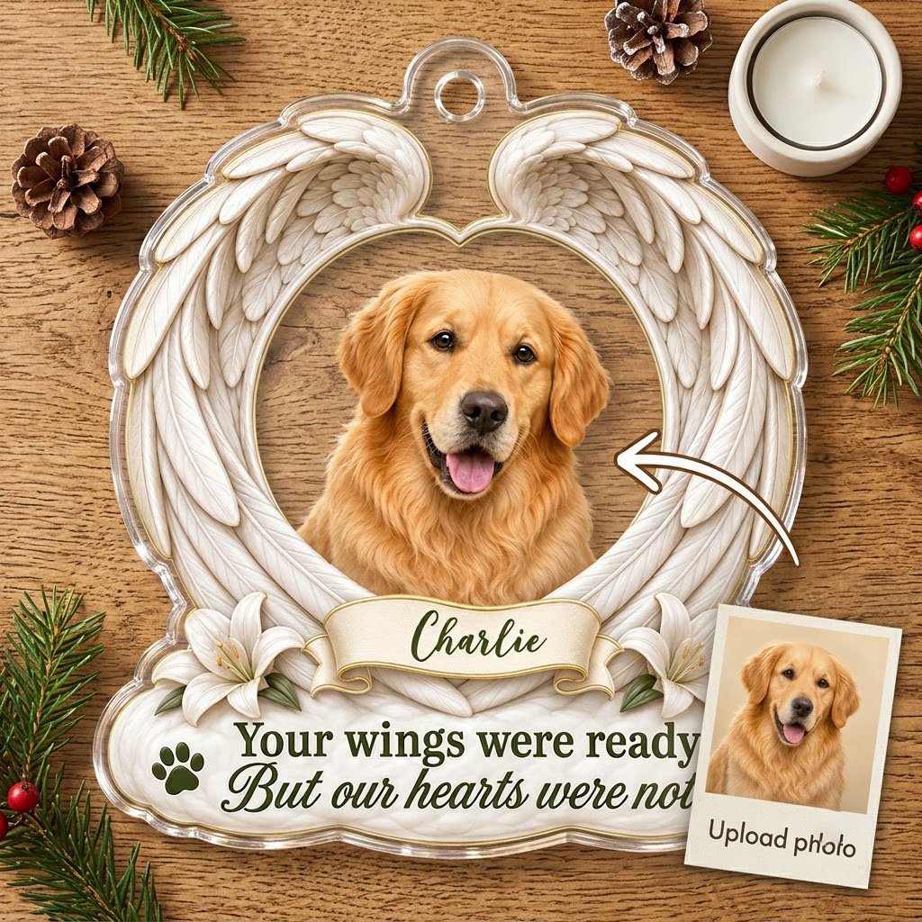 Clear acrylic angel wings ornament with a circular dog photo, white lilies, a dark green paw print, and a name banner.