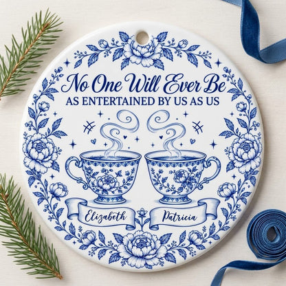 Round white ceramic ornament with blue floral border and two teacups, personalized with two names