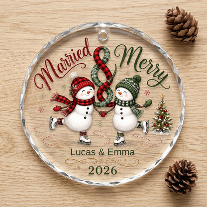 Round glass ornament with two ice-skating snowmen, a scarf ampersand above, and a small Christmas tree with star.