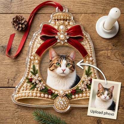Bell-shaped acrylic ornament with red velvet bow, pearl and gold accents, and a central circular photo frame.