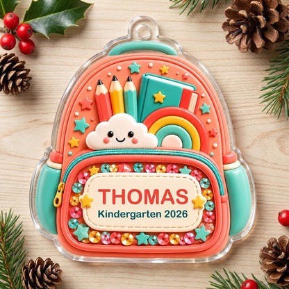 Coral backpack acrylic ornament with pencils, rainbow, smiling cloud, and 'THOMAS' Kindergarten 2026.