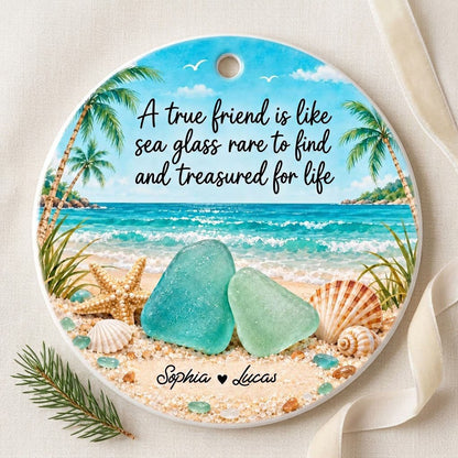 Round ceramic ornament with beach scene, palm trees, sea glass, shells, and a friendship quote with two names.