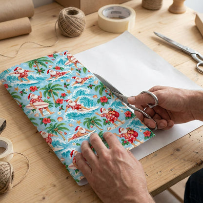 Surfing Santa with palm trees, hibiscus, starfish and seashells on light blue tropical wrapping paper.