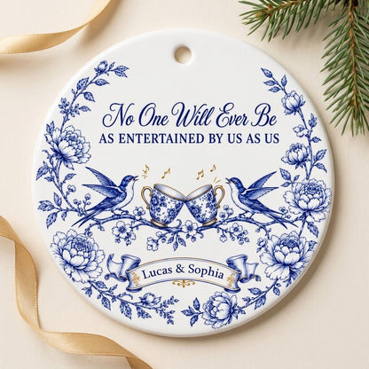 Round ceramic ornament with blue toile border, two birds, clinking floral teacups and gold music notes with two names.