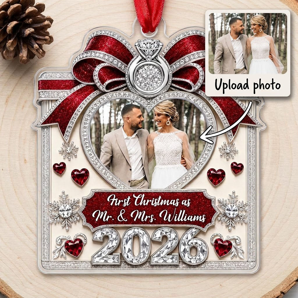 Acrylic ornament with red glitter bow, engagement ring, heart photo frame, snowflakes, and Mr. & Mrs. name and year.