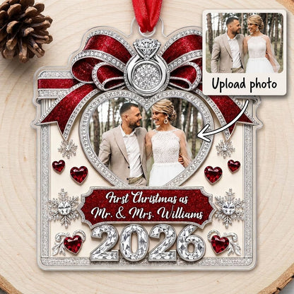 Acrylic ornament with red glitter bow, engagement ring, heart photo frame, snowflakes, and Mr. & Mrs. name and year.
