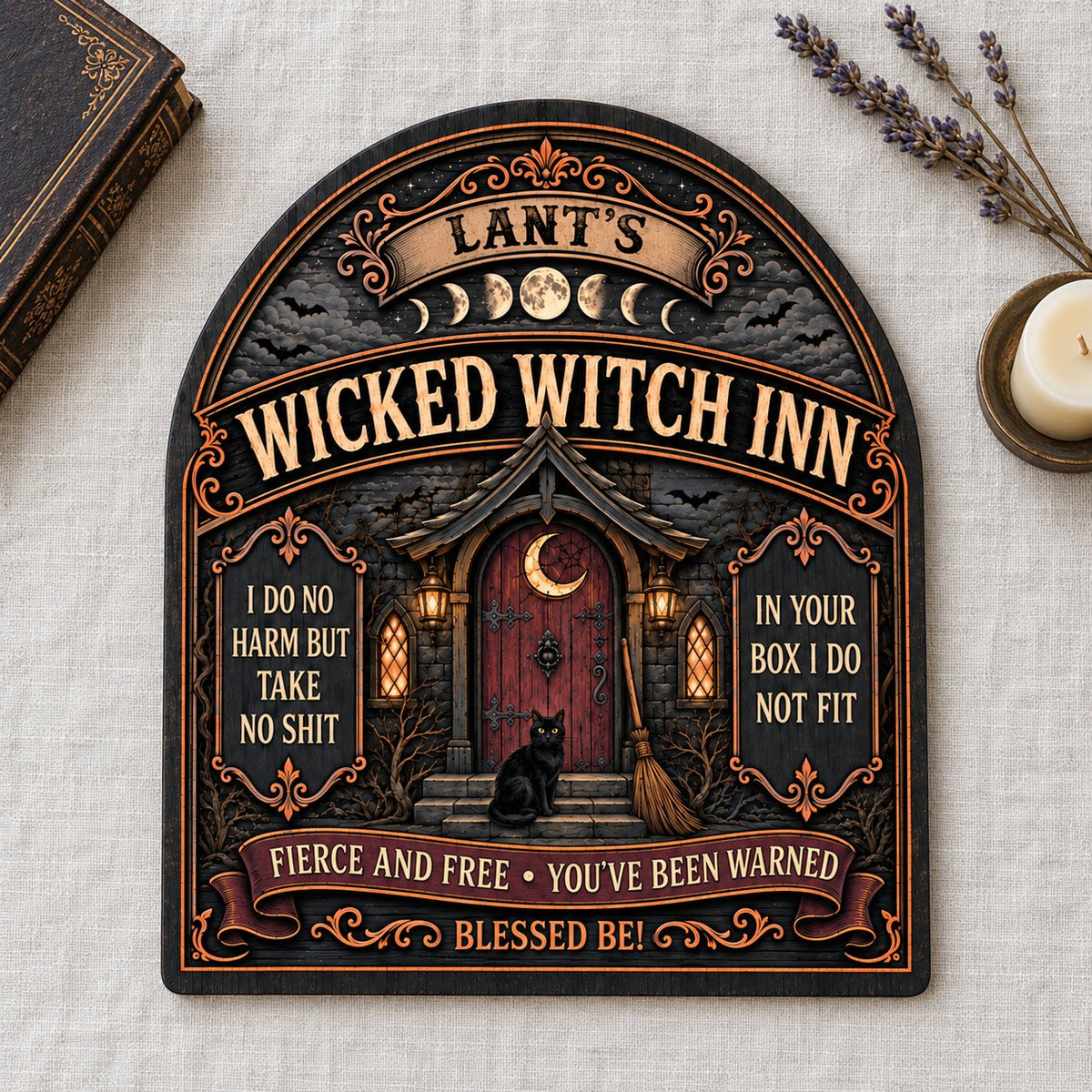 Arch wooden sign with a witch's cottage, bats, moon phases, red crescent door, broom, and a black cat on the steps.