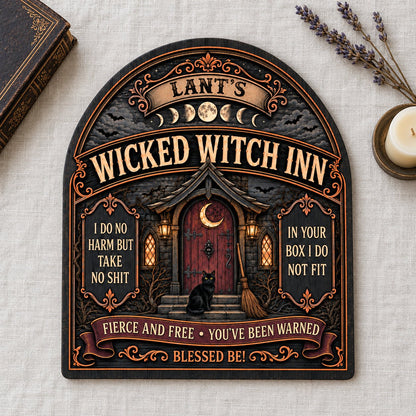 Arch wooden sign with a witch's cottage, bats, moon phases, red crescent door, broom, and a black cat on the steps.
