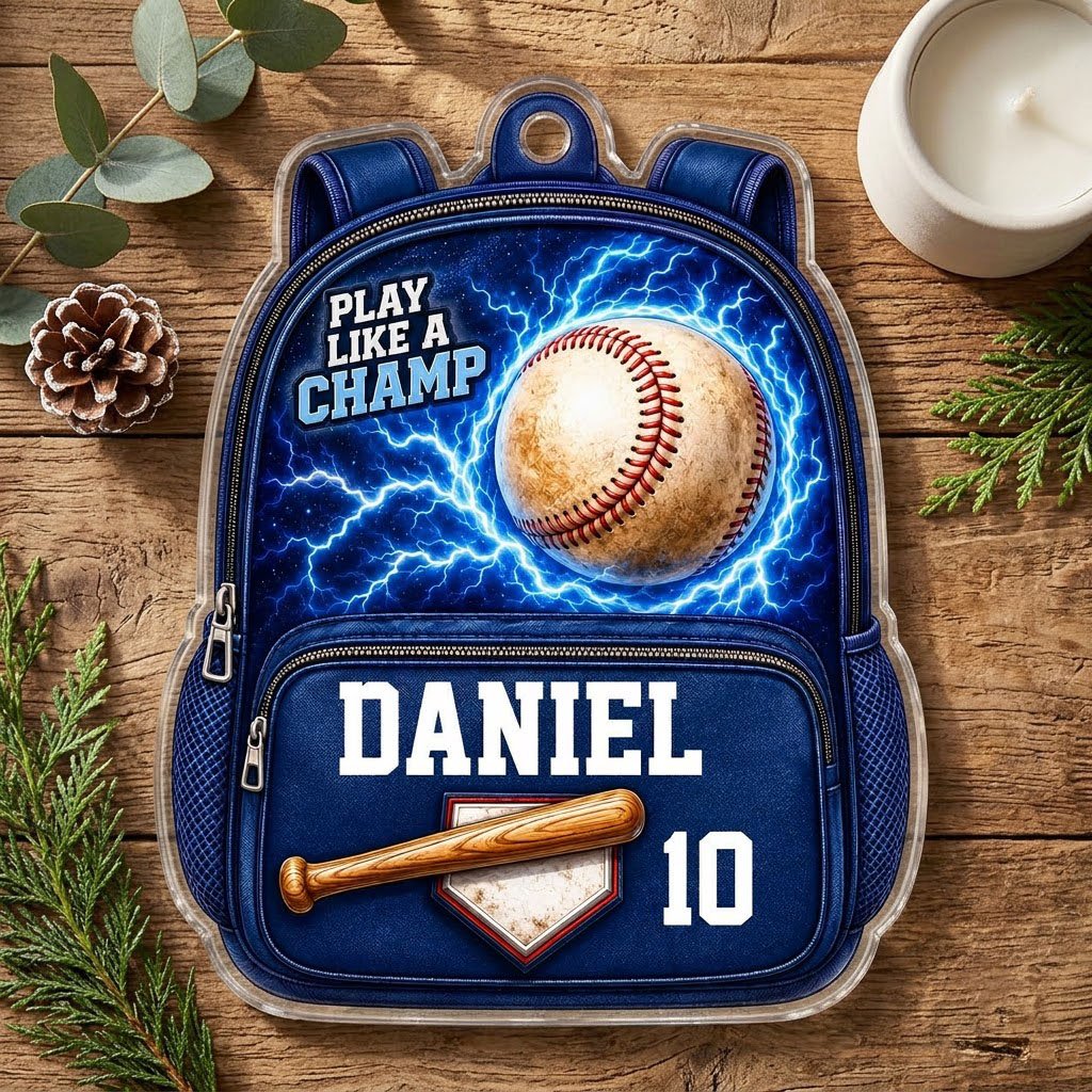 Backpack-shaped acrylic ornament with a baseball, blue lightning, a bat on home plate, and PLAY LIKE A CHAMP text.