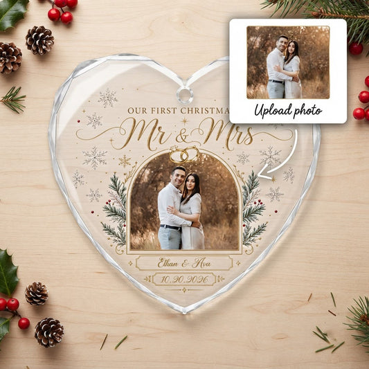 Heart-shaped glass ornament with photo, gold wedding rings, pine branches, snowflakes, and Mr & Mrs text.