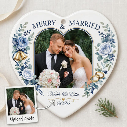 Heart ceramic ornament with “MERRY & MARRIED,” dusty blue florals, wedding bells, rings, and a heart-shaped photo frame.