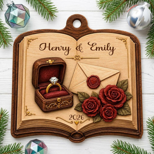 Open book wood ornament with a ring box, red roses, wax-sealed envelope, and custom names and year.