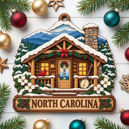 Log cabin ornament with NORTH CAROLINA banner, red cardinal, banjo, dogwood flowers, pine trees, and blue mountains.