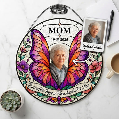 Round stained-glass suncatcher with butterfly wings, purple and pink flowers, a photo arch and a name banner.