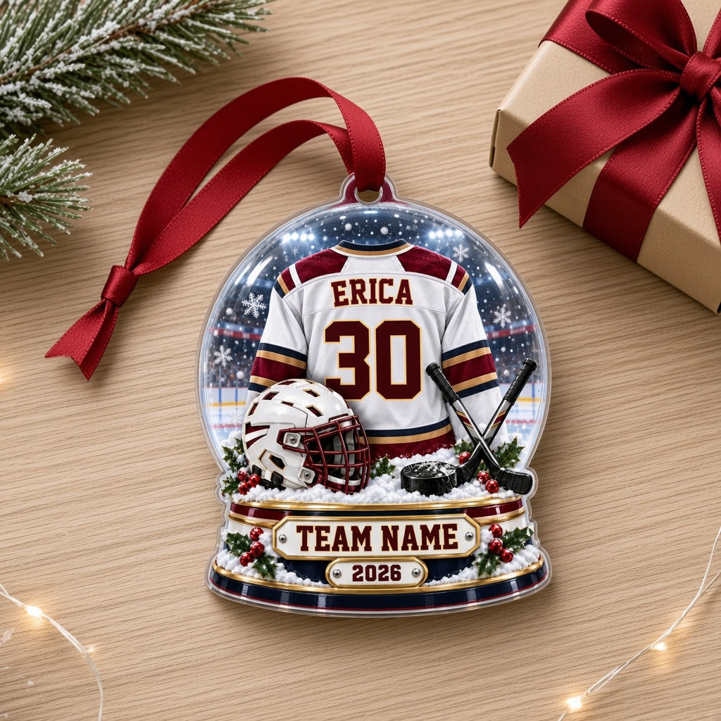 Acrylic snow globe ornament with hockey jersey, helmet, crossed sticks, puck, snowflakes and holly accents.
