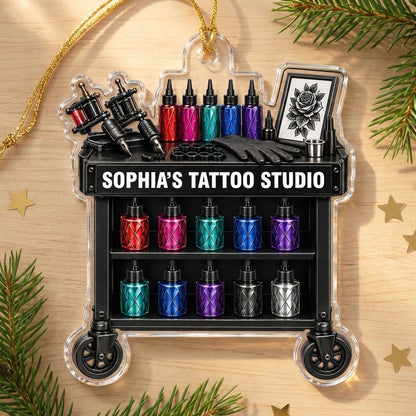 Acrylic ornament shaped like a tattoo cart with machines, colorful inks, and 'SOPHIA'S TATTOO STUDIO' text.