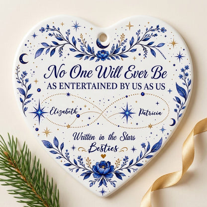 White heart ceramic ornament with blue florals, moons, stars, and “Written in the Stars Besties” with two names.